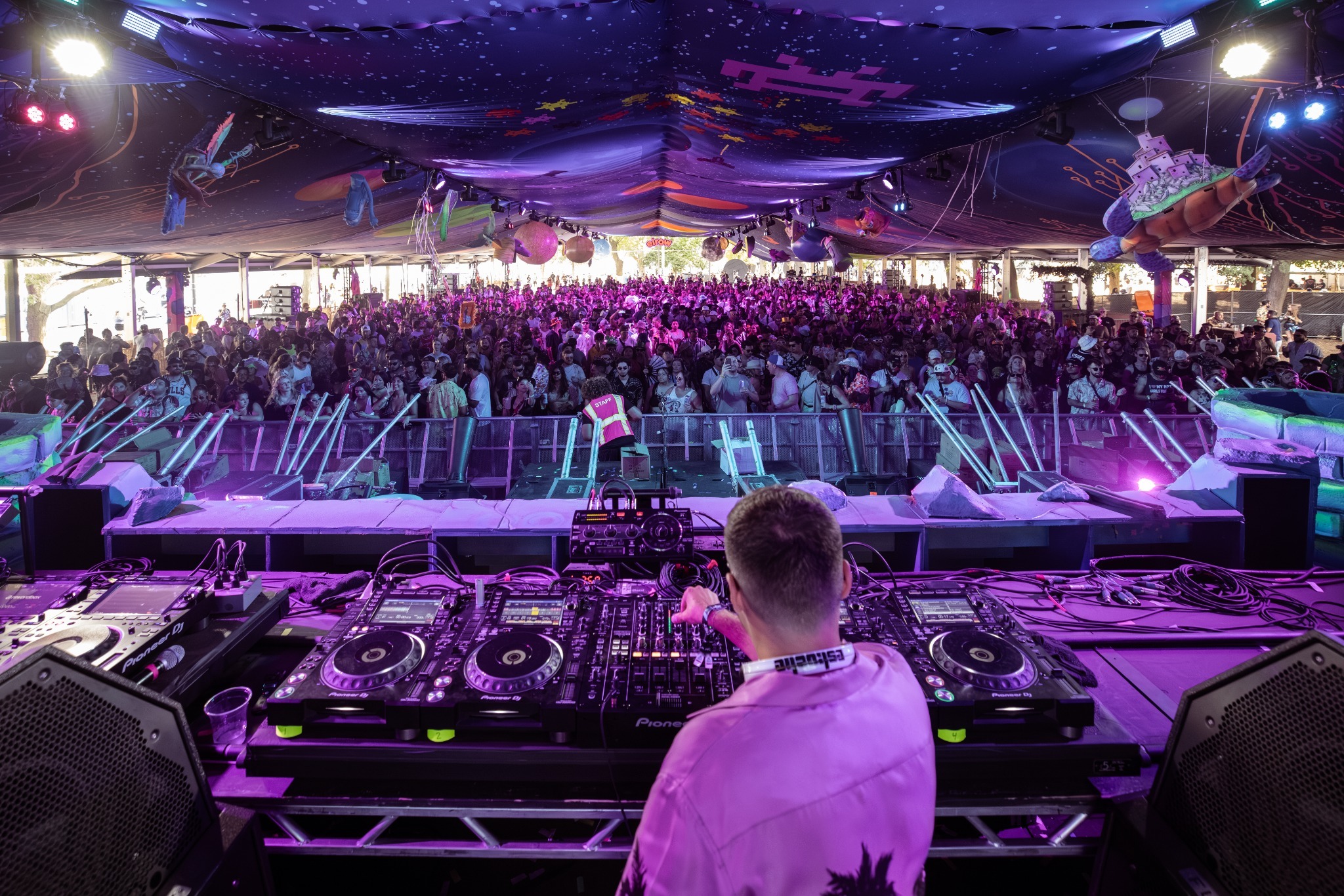 ESKUCHE performing to a festival crowd beneath a purple elrow canopy